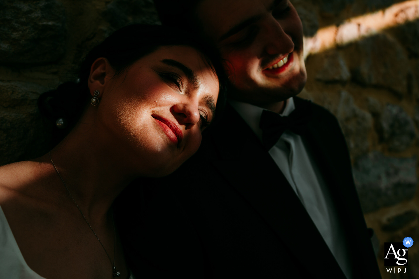 A ray of sunlight illuminates the bride and groom's faces at Domaine de la Trinité.