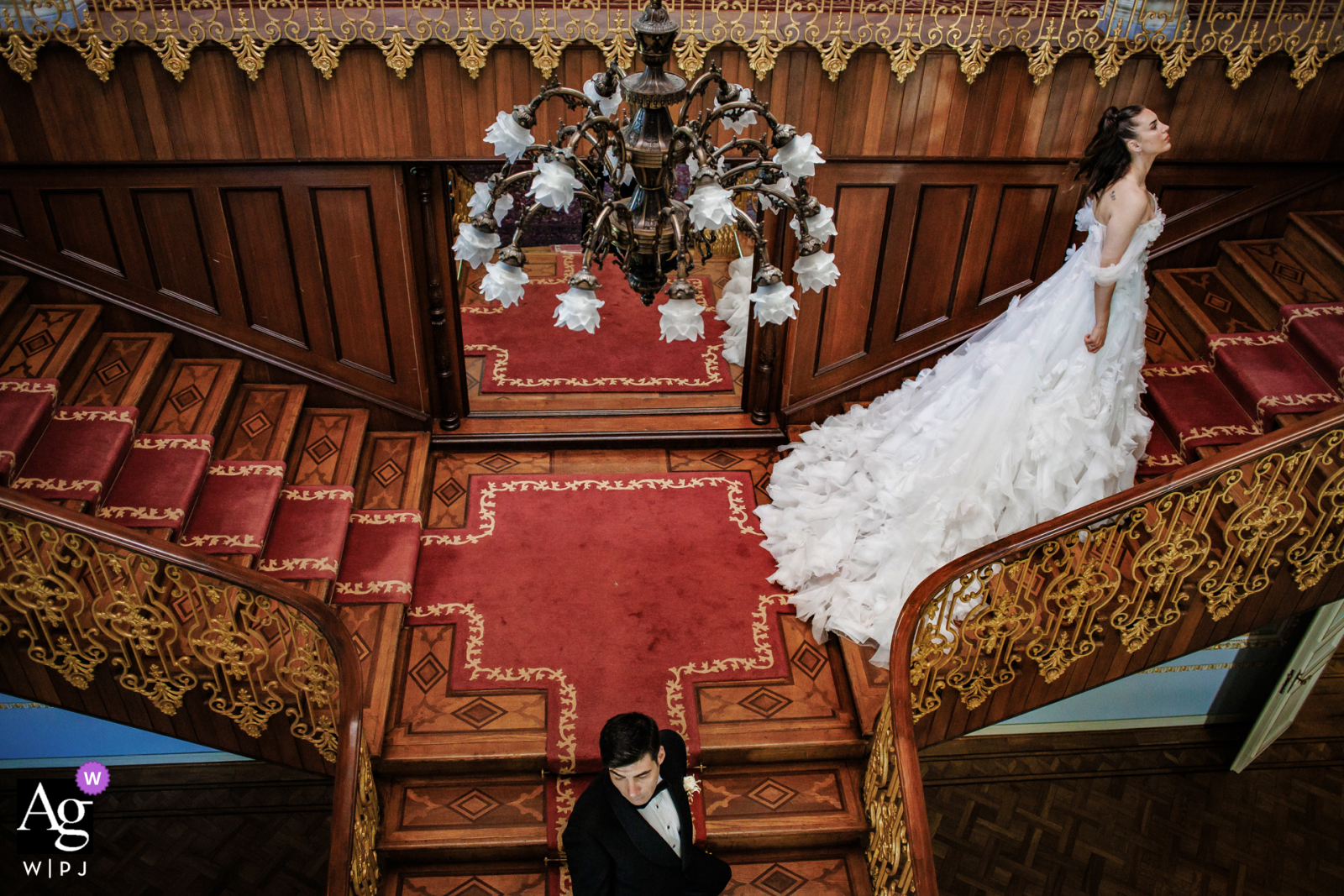 Symmetrical Artistic Wedding Portrait On Stairs At Sait Halim Paşa Yalısı Istanbul Mansion Sait Halim Paşa Yalısı, Istanbul — In a symmetrical wedding day portrait, the bride ascends the stairs while the groom walks down and away, positioned lower and center in the frame, creating a dynamic and artistic image at the historic waterfront mansion.