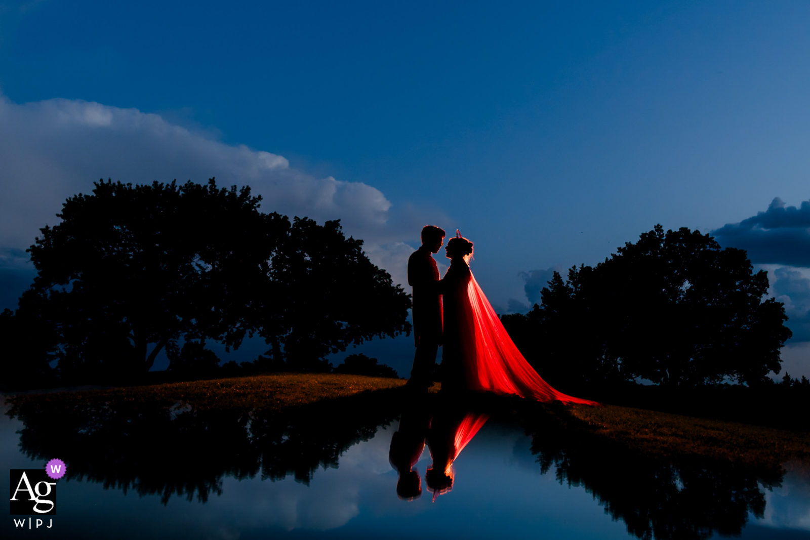   During sunset at a Missouri wedding location, the couple is beautifully backlit, their silhouettes warmly highlighted against the fading glow of the day.