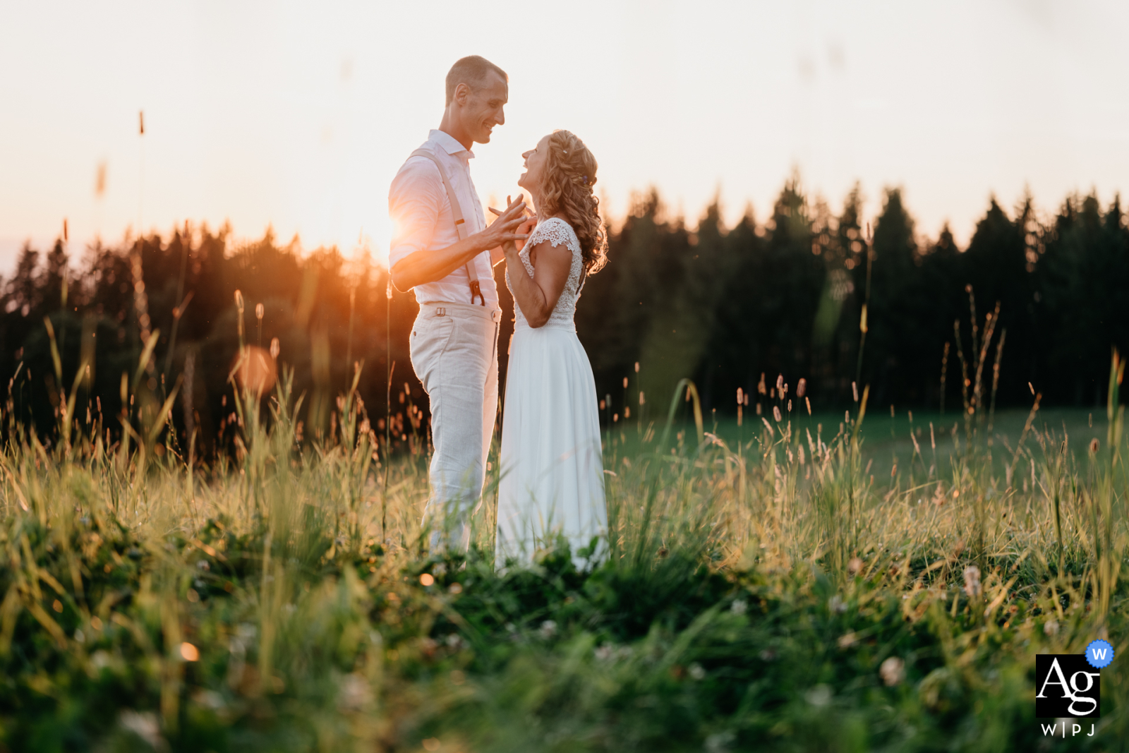   Near the ceremony location in Giffers, Switzerland, the couple stand together in the grass, the natural surroundings providing a serene backdrop for their wedding portrait.