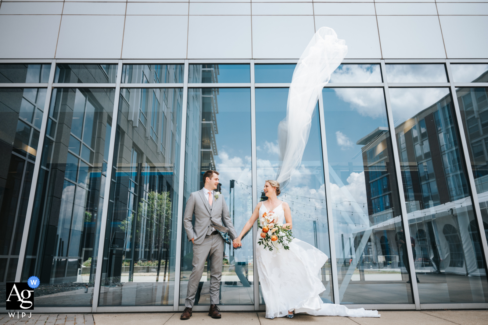   At Lago Custom Events in Cleveland, Ohio, the bride’s veil is caught dramatically by the wind, adding an unexpected and dynamic element to this wedding image.