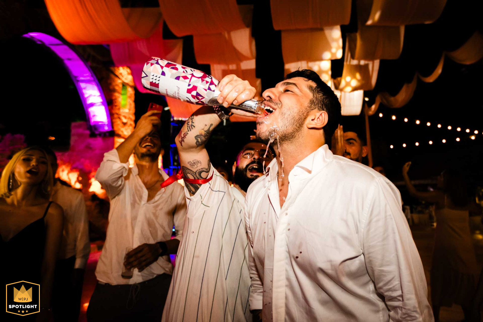 Wedding photo taken at Divan Hotel Mersin - Groom drinking champagne from friend's bottle. Candid moment captured by the photographer.