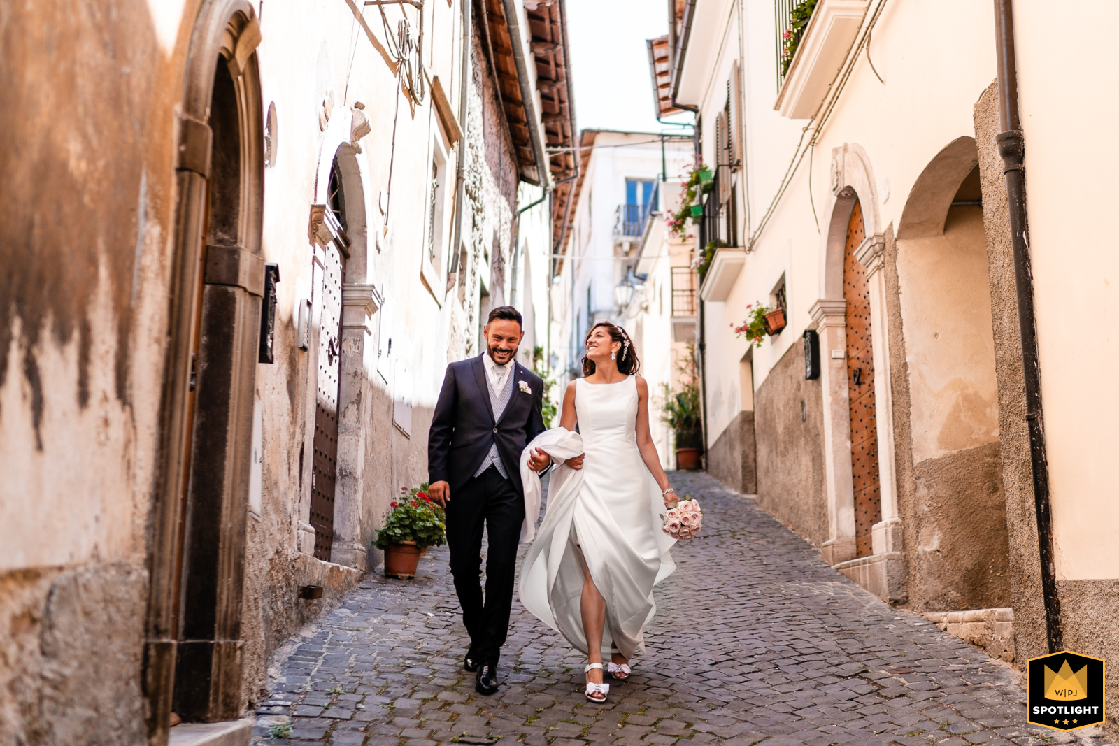 Capture the Romance: A Stunning Wedding Photo in the Heart of Abruzzo In the heart of Abruzzo, a bride and groom explore the historic streets of Pettorano Sul Gizio, their love story beautifully documented in a captivating wedding photograph
