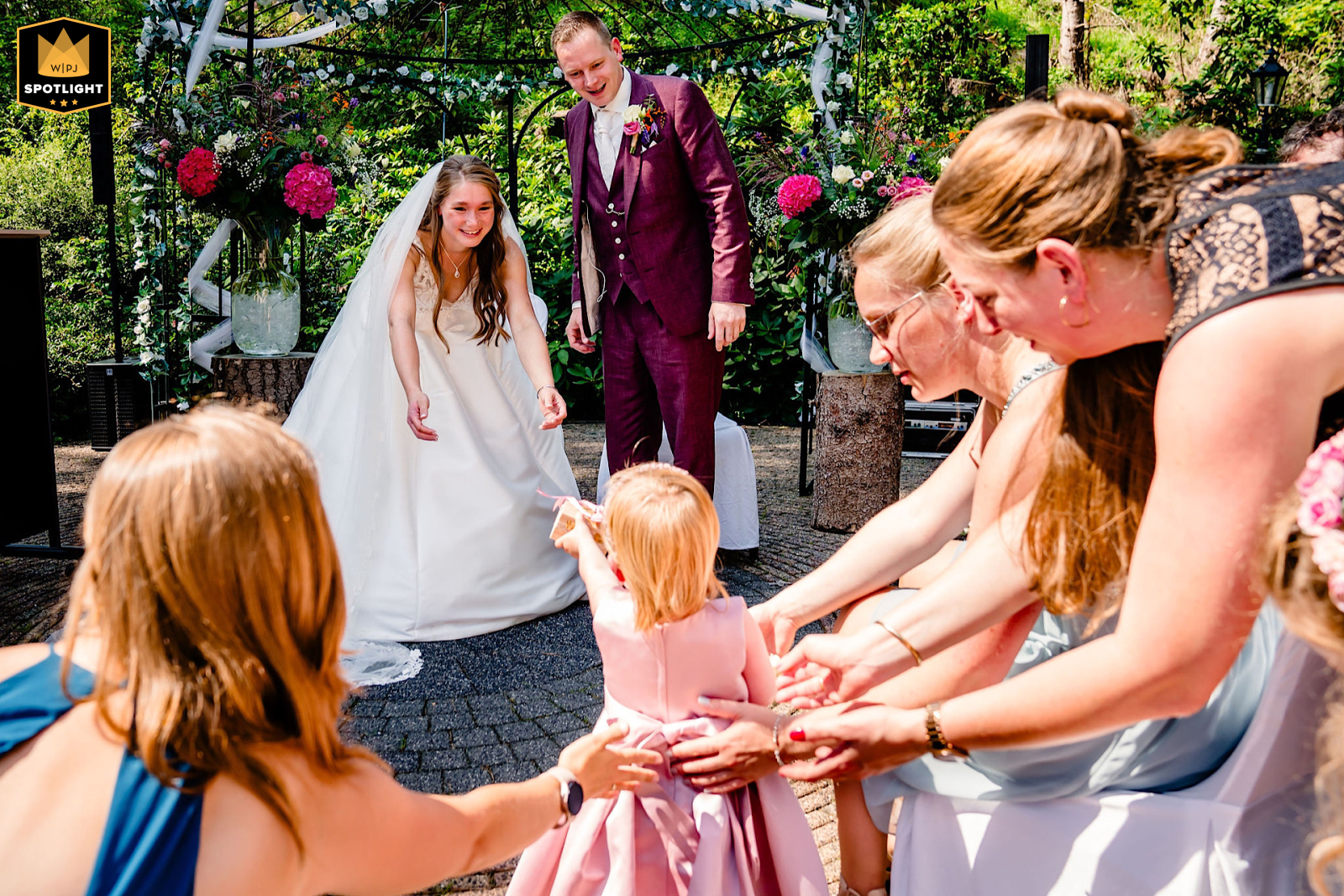 This award-winning wedding image captures a heartwarming moment at a Gelderland, Netherlands wedding venue, as the daughter proudly presents the rings to the happy couple.