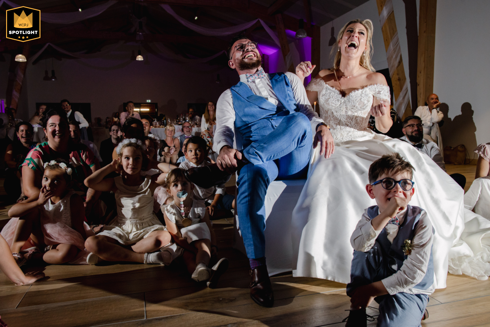 At the Vienne reception venue, the newlyweds share a laugh while watching a video, captured in a lighthearted and joyful moment during their celebration.