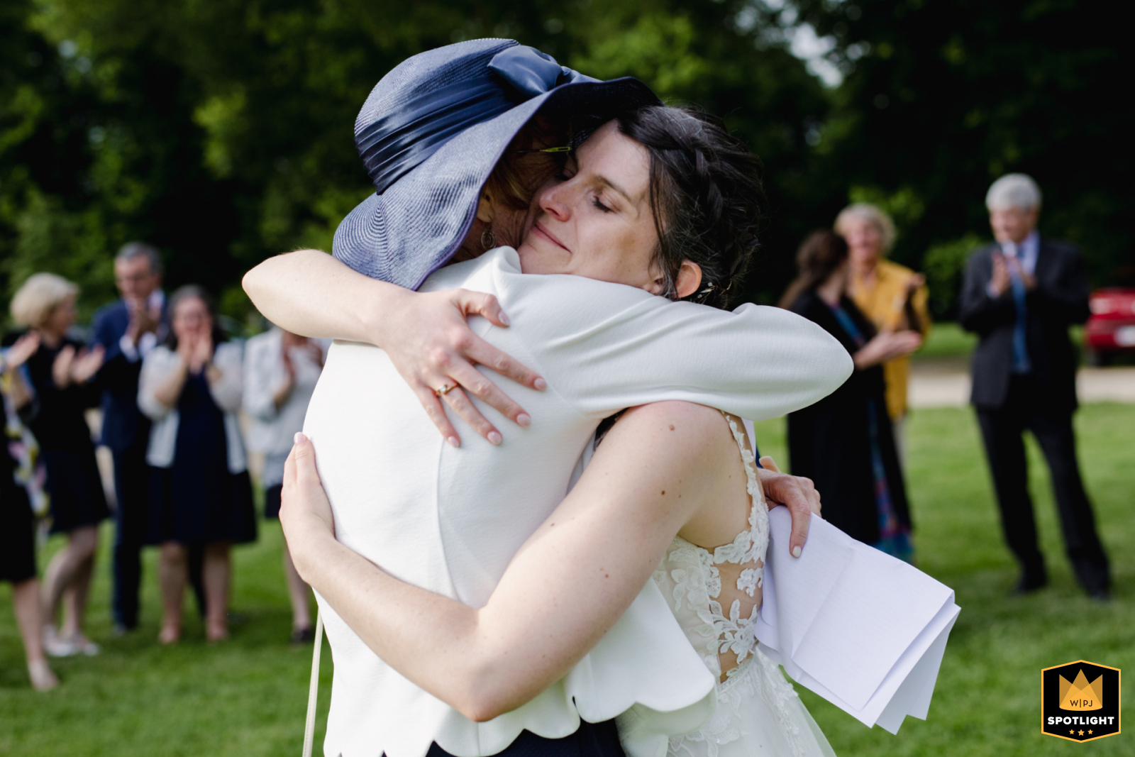 In Poitiers, Vienne, at the reception venue, the bride shares a hug with her mother on the grass.