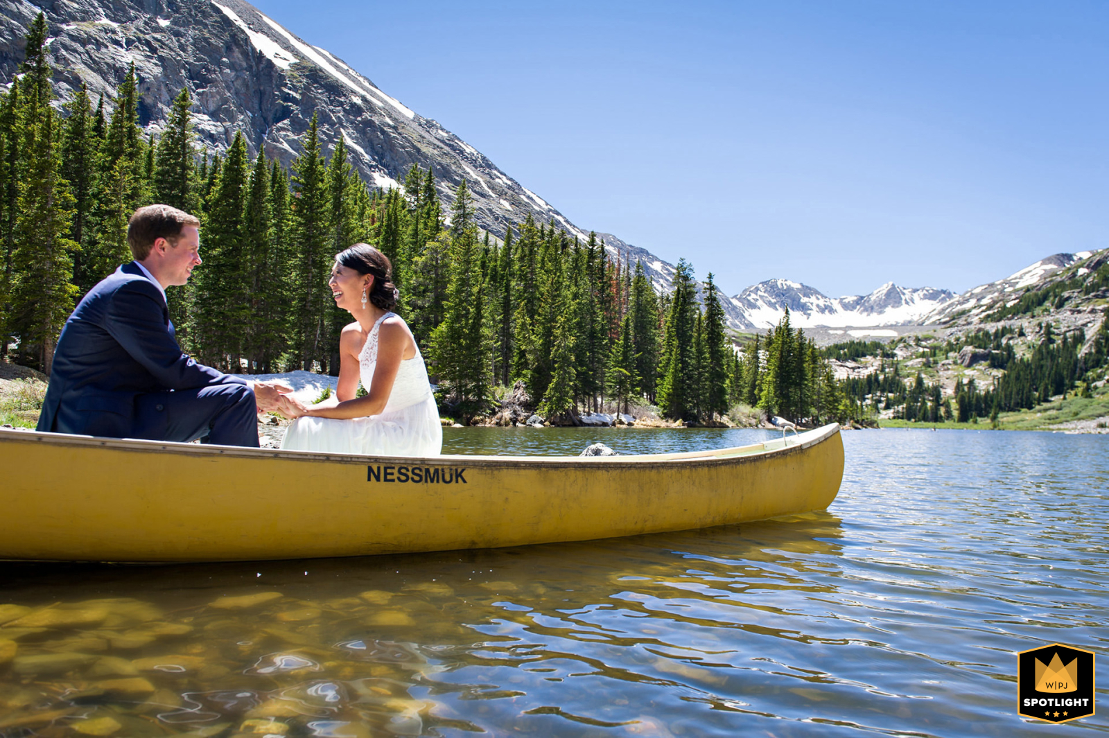 A couple enjoys a canoe ride on Blue Lakes in Breckenridge, Colorado, set against a scenic backdrop of clear water and surrounding natural beauty.