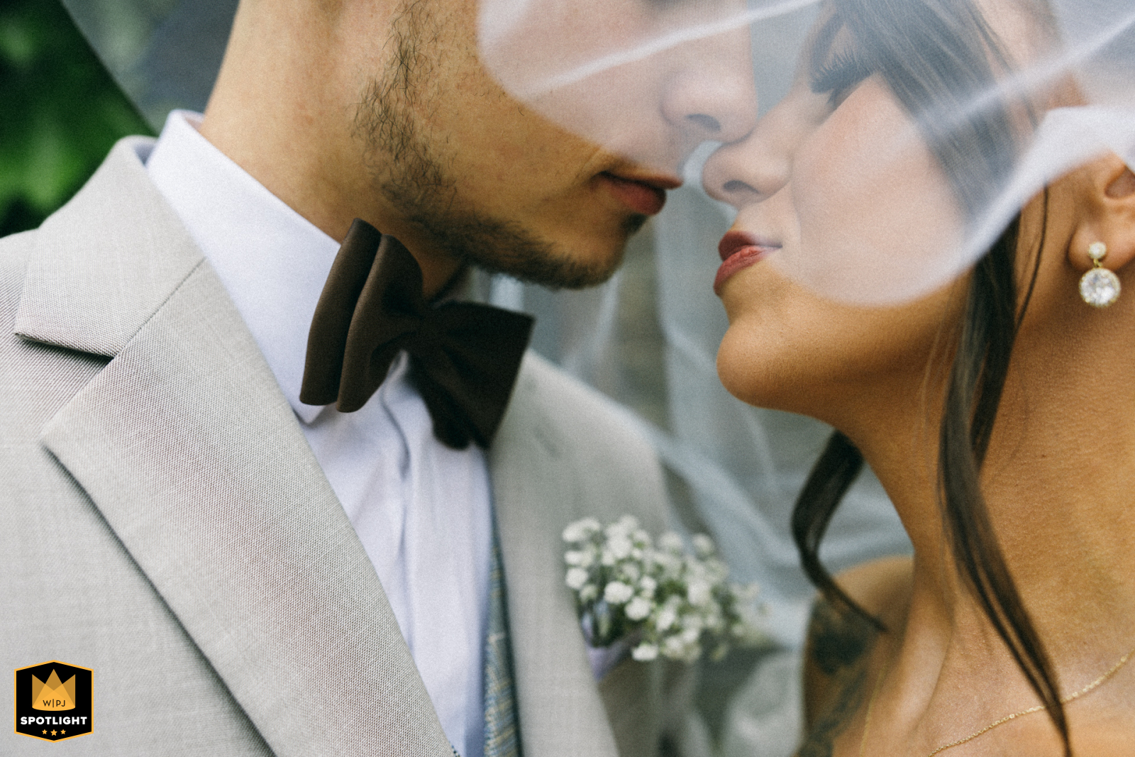 Next to the hotel in West Pomeranian, Poland, a tight shot of the bride and groom's faces during their reception session, softly obscured by her veil.
