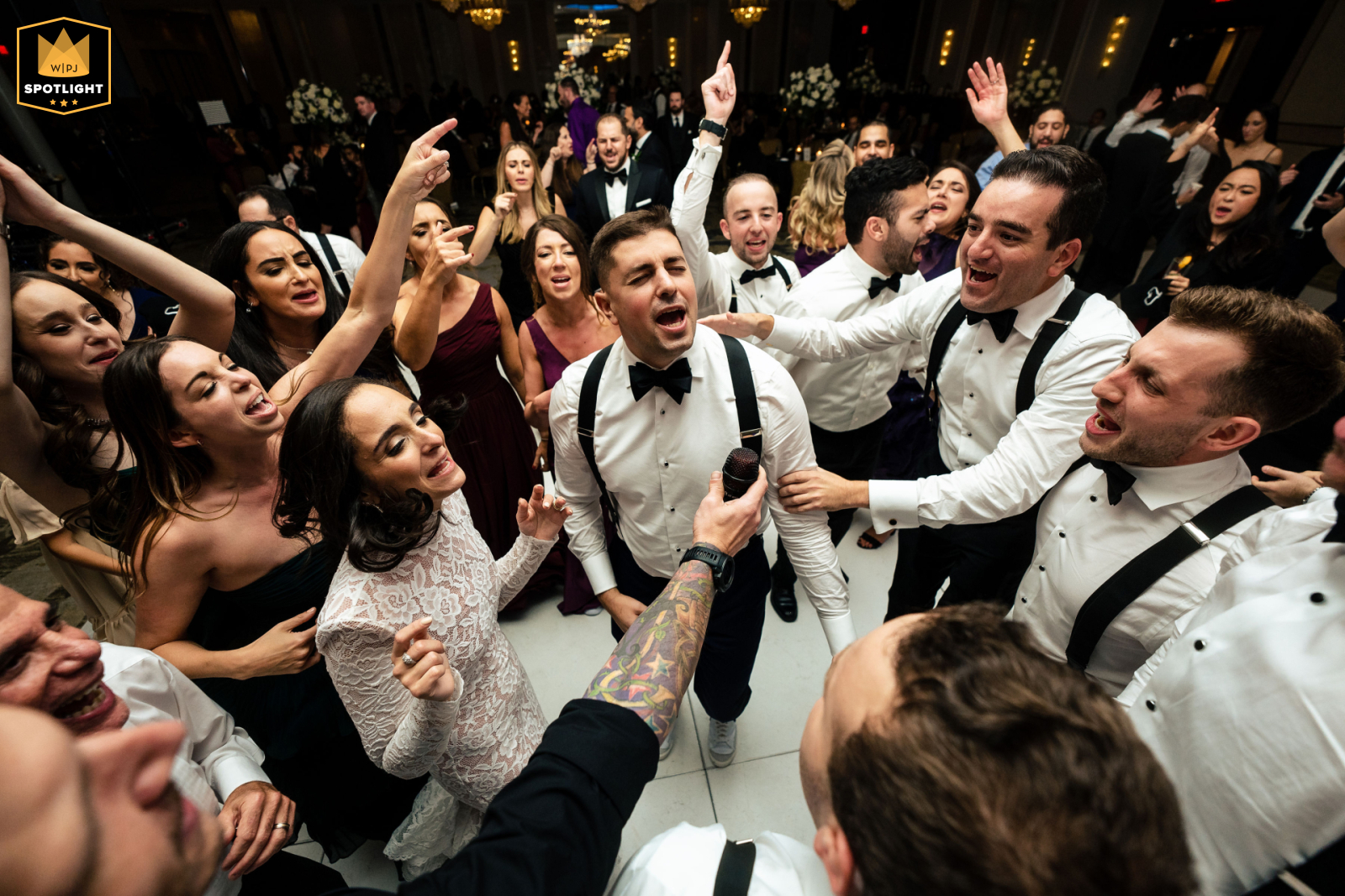 Hilton Philadelphia: Wedding Couple Serenades Cherished Crew Hilton, Philadelphia: A high, wide-angle view shows the bride and groom serenading their special day, encircled by their cherished crew.