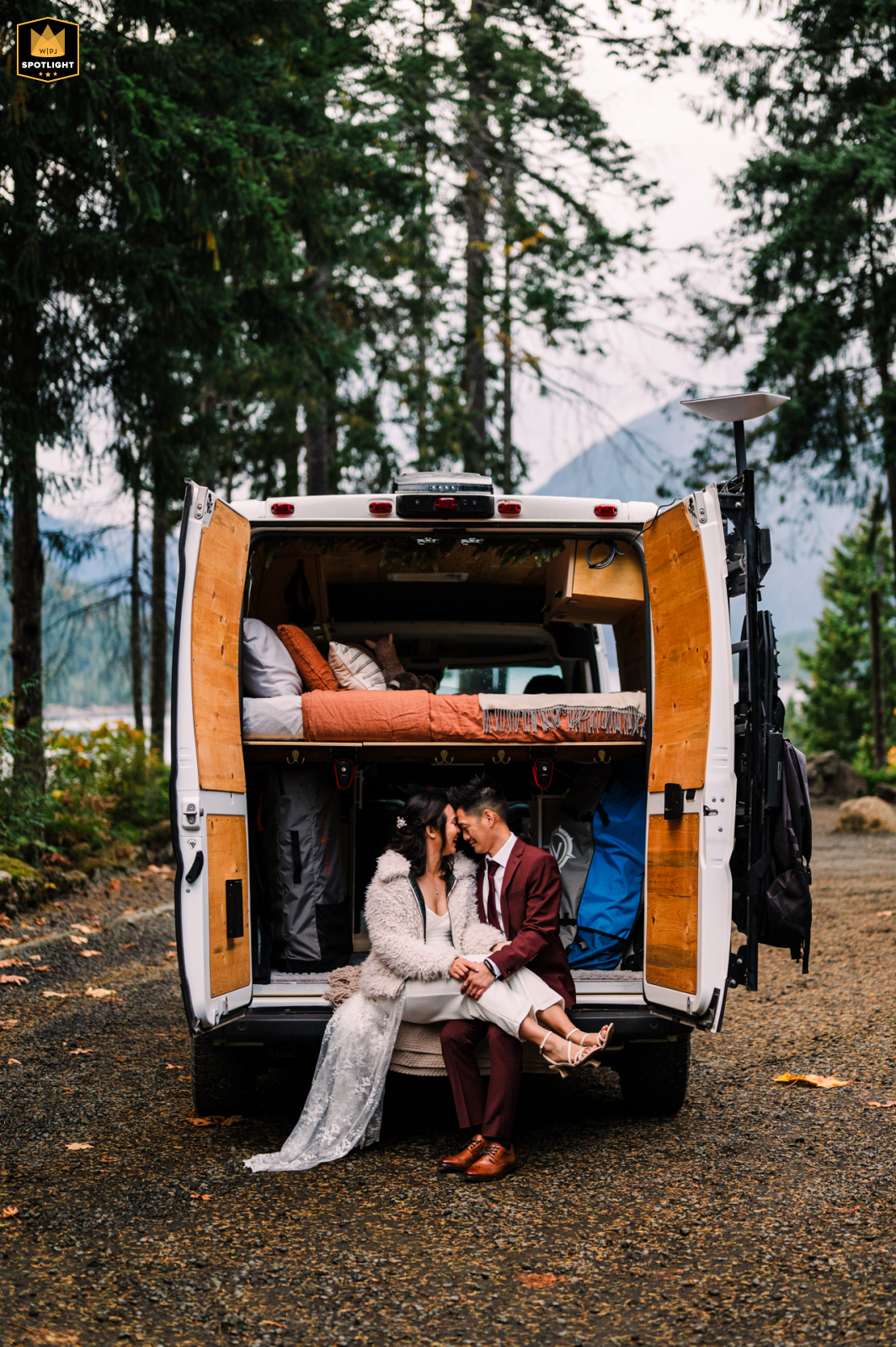 Lake Cushman Wedding Portrait: Cozy Camper Van Snuggles At Lake Cushman, WA, a bride and groom snuggle in their camper van, their home on wheels for many adventures.