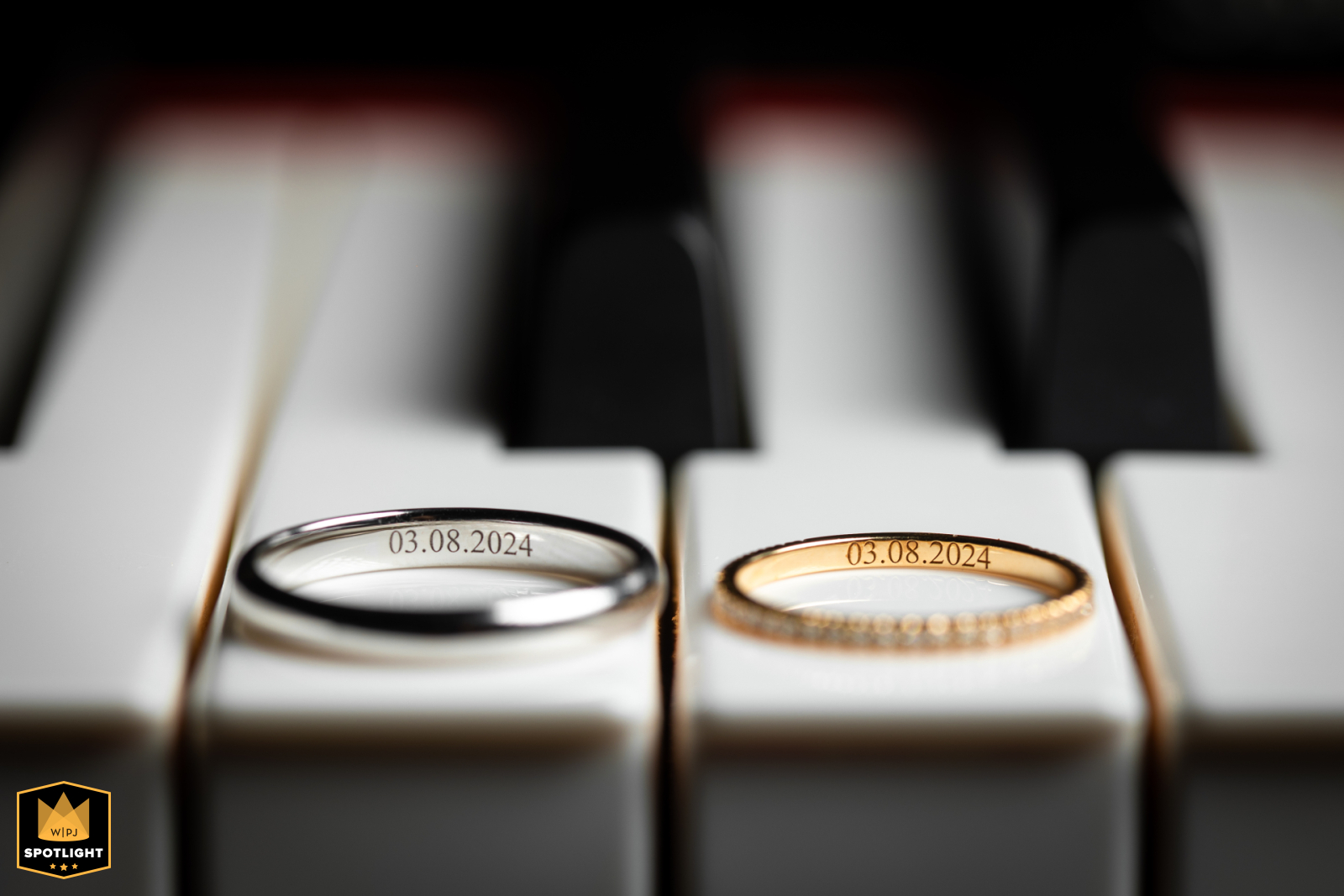 Wedding rings rest on the black and white keys of a piano in Vienne. The image captures a classic and elegant detail of the wedding day.