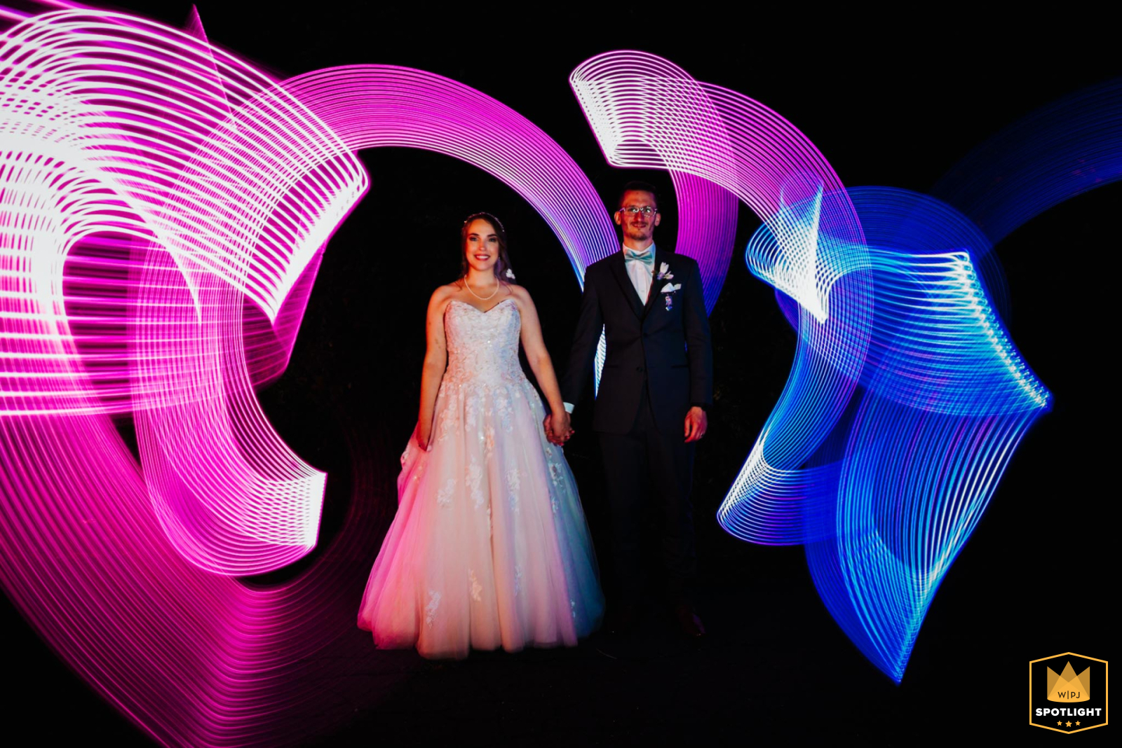 A couple stands still for a long-exposure photo at La Bella Vista in Central Connecticut. A photographer creates a light design around them with a light saber, creating a unique and artistic portrait.