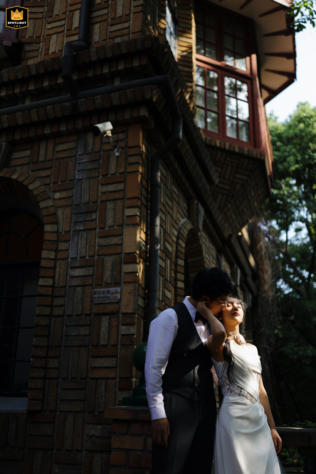 Moller Villa, Shanghai. Tenderly embracing newlyweds in front of a vintage building, bathed in beautiful light and shadow.