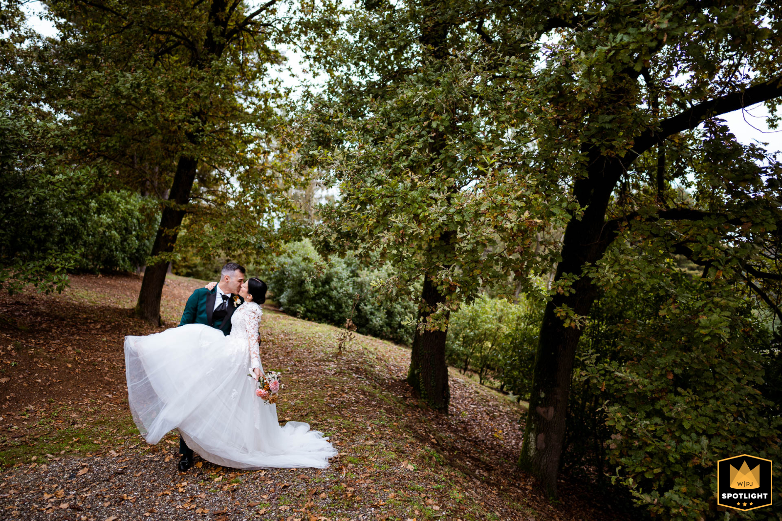 A portrait of a newlywed couple is captured at Tenuta Montezeglio in Invorio, Italy. The image shows the pair in the park of the estate during their wedding reception.