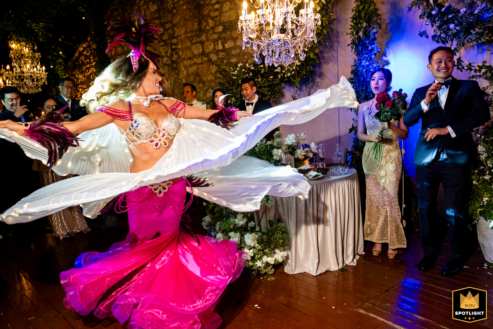 At Six Senses Kocataş Mansions, İstanbul, a wedding photographer captures a dazzling performance. The newlywed couple watches from their table as a vibrant belly dancer commands the stage with a captivating show.