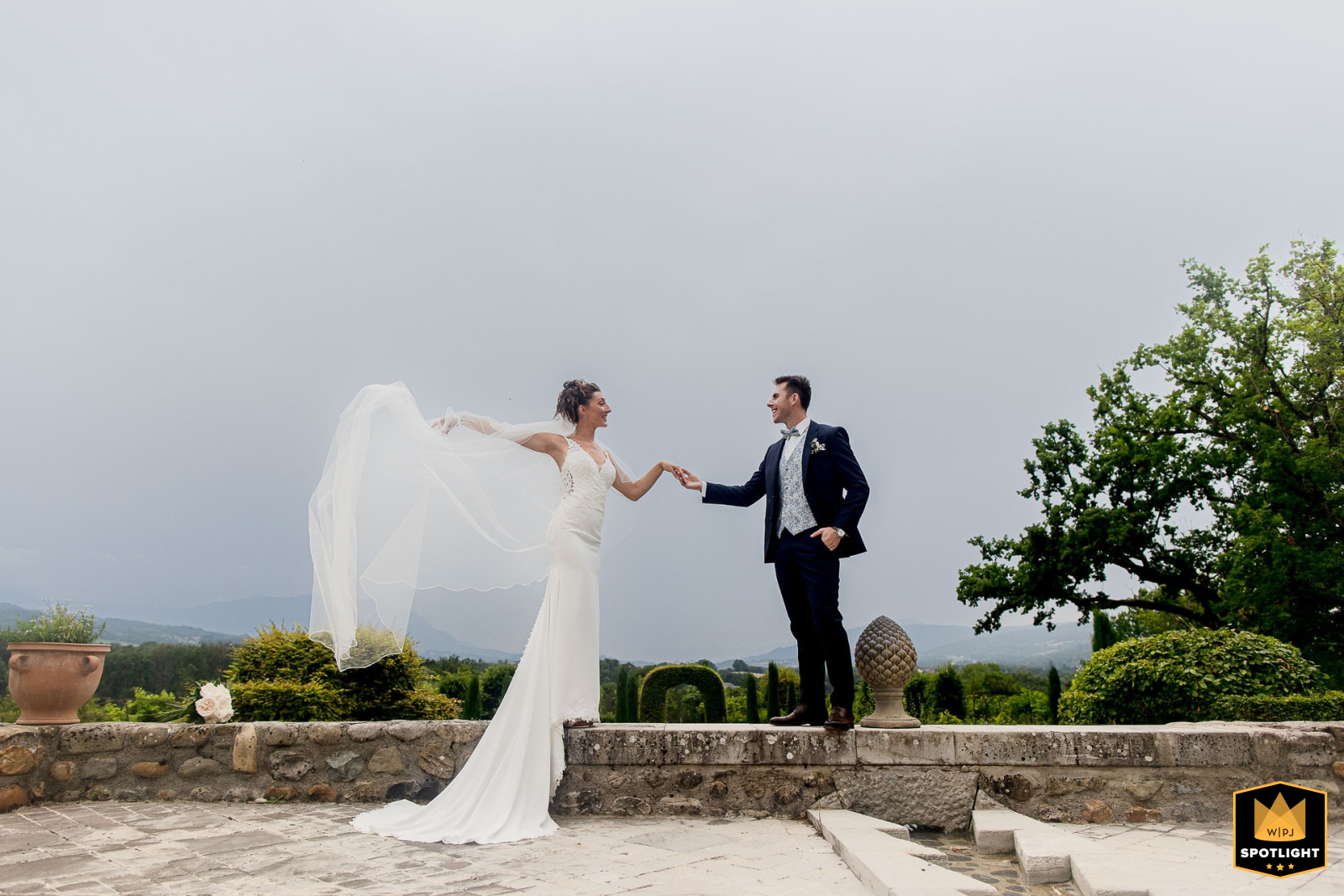 Bride and groom in France pose for a portrait at La Médicée, the bride's flowing gown adding elegance.
