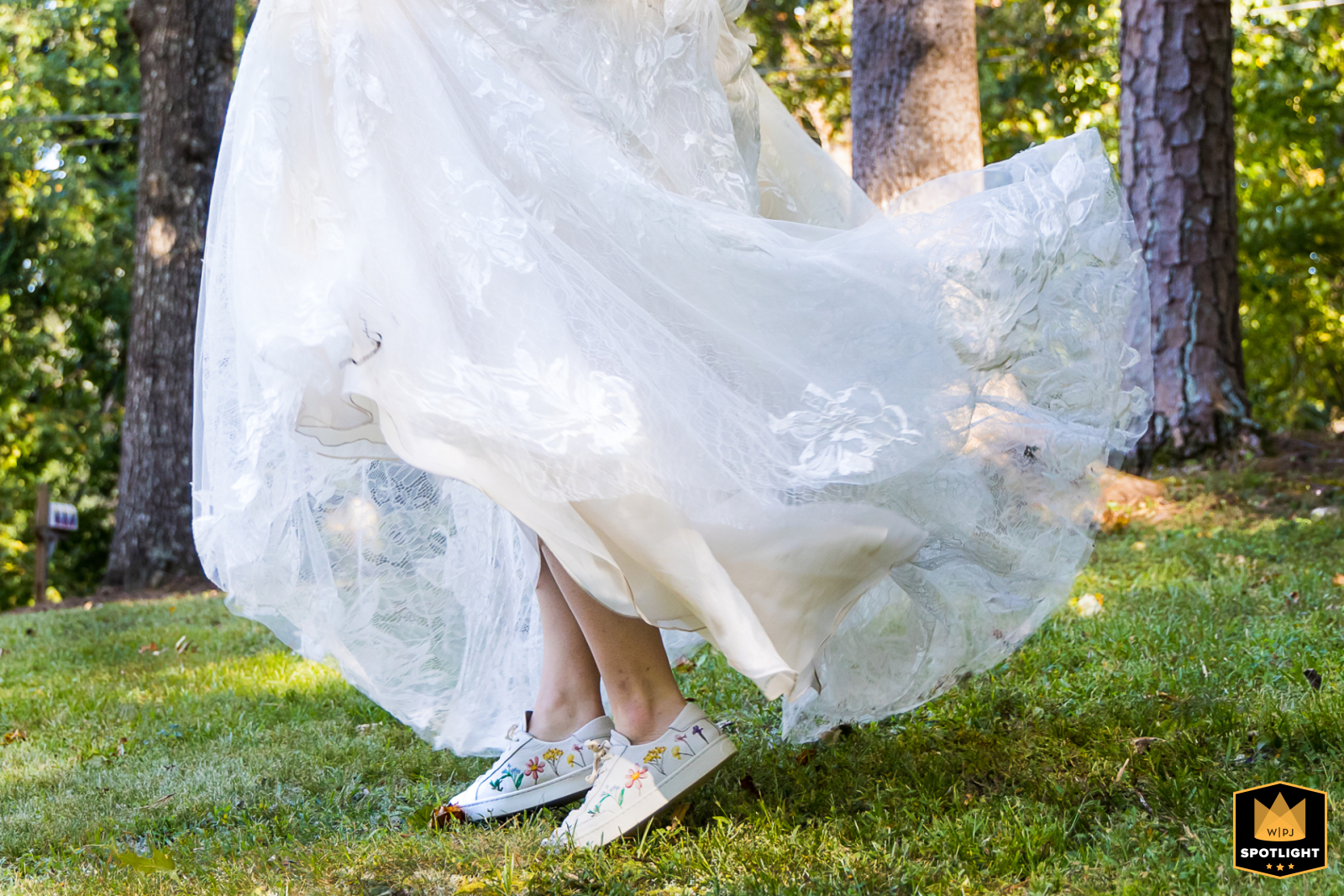 Bride standing in the backyard of a home in Atlanta, Georgia, with her tennis shoes playfully visible beneath her wedding dress.