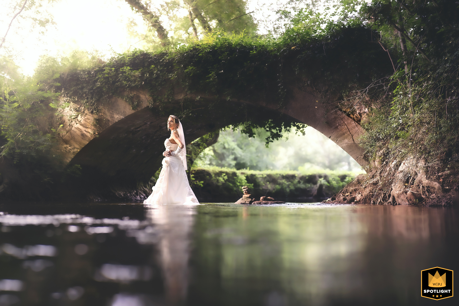 Bride Embraces A Playful Moment In The Water In Lembras, Dordogne, France In Lembras, Bergerac district, Dordogne, France, a bride braves getting wet for a truly unique wedding photo filled with fun and spontaneity.
