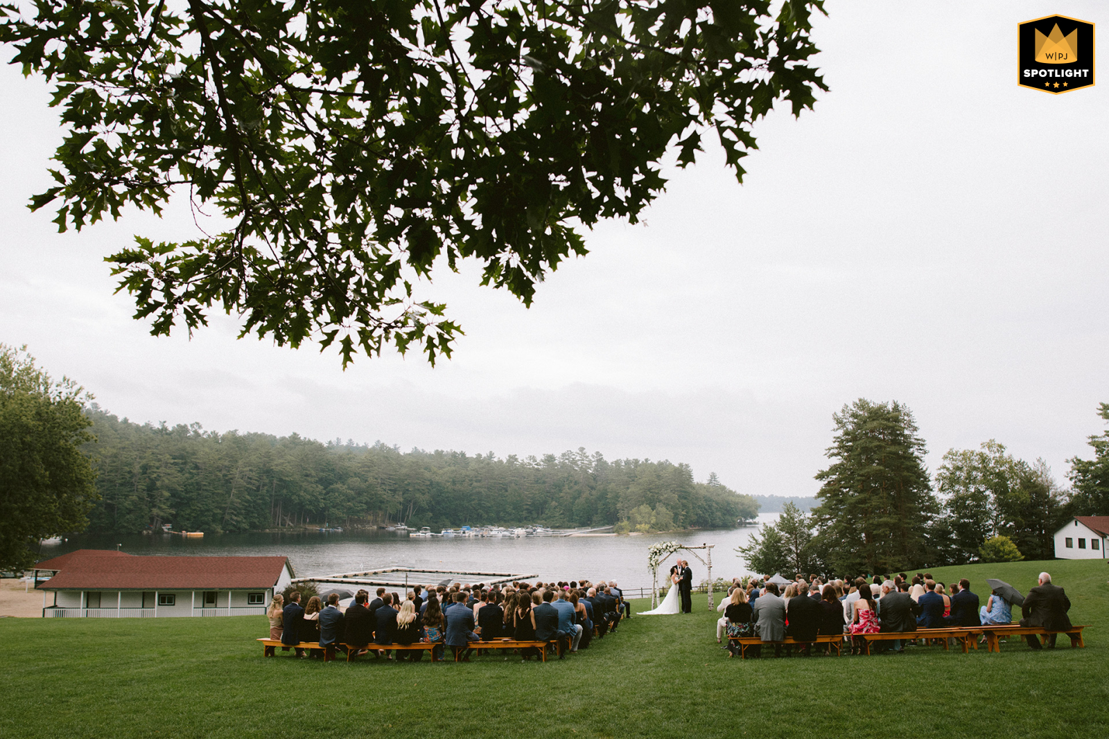   The ceremony on Sebago Lake, Maine, unfolds in a veil of fog, providing a dreamlike lakeside backdrop that highlights the couple’s vows and their unforgettable setting.