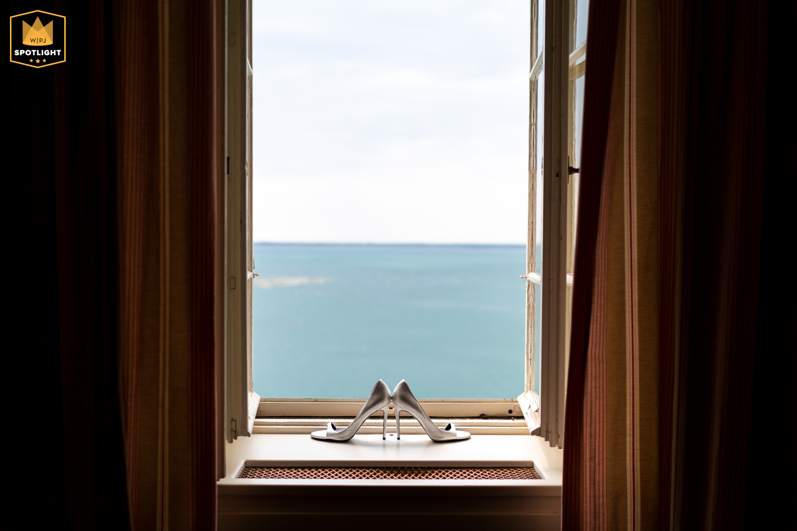   At Castello di Duino, Duino, Trieste, Italy, the bride’s delicate shoes rest gracefully on a windowsill, their placement offering a stunning view overlooking the sparkling sea.