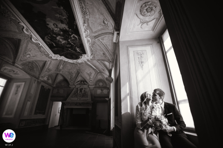 The couple had a small wedding at a museum. They had the ceremony indoors and then the couple posed for a portrait by a window at the museum.