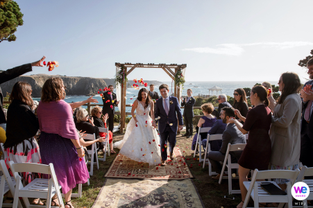 On a sunny day with a clear, blue sky, the bride and groom receded down the aisle as guests threw rose petals; it was a small, yet intimate wedding ceremony