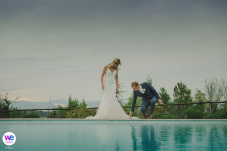 A small wedding at a villa was made special as the groom lovingly adjusted the bride's dress for their portrait
