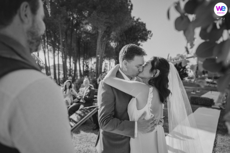 countryside bride and groom kissing at outdoor ceremony