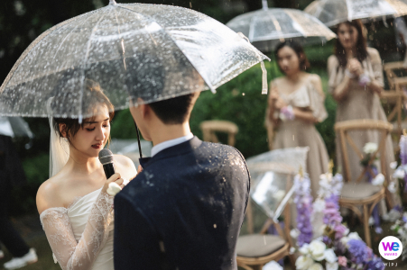 The couple shares a heartfelt moment in the rain, blurring the lines between raindrops and tears. A unique wedding experience.