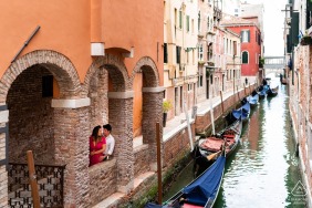 Prewedding engagement shoot at a canal with gondolas in Venice, Italy
