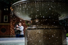 Pre-wedding photo-session in Boston, Massachusetts as A couple laughs while framed by a water fountain