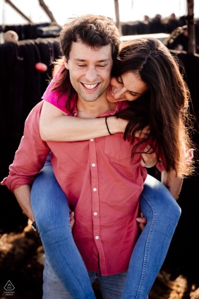 A couple is smiling in the sunshine of Montpellier, France, while the woman is being given a piggyback ride