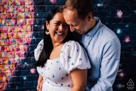 The couple shared a tender embrace against the backdrop of South Bank, London, enveloped in each other's arms before a vibrant brick wall adorned with cosmic urban street art.