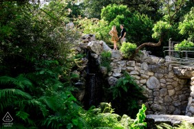 A couple poses amidst the stunning multi-level stone wall gardens of Zilker Botanical Garden in Austin, TX during their pre-wedding photo shoot.