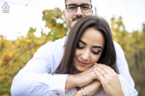 She rests gently in his arms at Etyek, Hungary, where a quiet smile reveals the calm certainty of being exactly where she belongs during this peaceful and romantic engagement portrait.