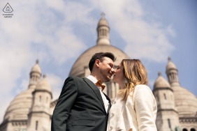 Two lovers share an iconic kiss in the heart of Paris, France, celebrating their engagement with a timeless and elegant gesture in one of the world's most romantic city settings.