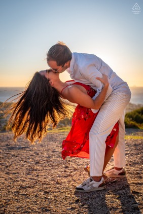 A future bride and groom share a romantic kiss by the edge of a dramatic cliff in Six-Fours-les-Plages, Var, Provence, France, overlooking the vast and beautiful sea below.