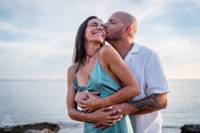 A bride and groom share a warm embrace while hugging by the sea in Bandol, Var, Provence, France, with the gentle Mediterranean waves providing a serene backdrop for them.