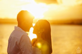 The warm light of a sunset on the lake illuminates this engaged couple at Lago di Bolsena, Italy, creating a serene and timeless atmosphere for their romantic outdoor portrait session.