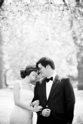 A couple stands close together during their romantic engagement photoshoot in London, UK, celebrating their commitment to one another.