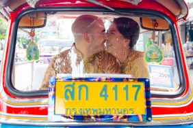 A happy couple enjoys a playful and unique engagement session featuring a traditional tuk-tuk at the Bizotel Premier Hotel in Bangkok, Thailand, celebrating their love with local flair.
