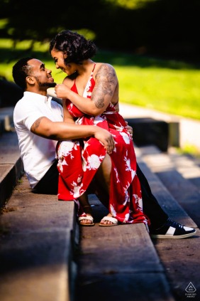 This couple is settled comfortably into each other’s space, sharing joyful smiles in the warm afternoon glow during their romantic engagement session at the Philadelphia Museum of Art in Pennsylvania.