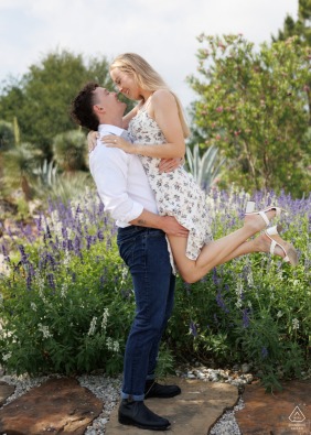 An excited young couple shares a joyful embrace immediately after their proposal at the Houston Botanic Gardens, celebrating their new engagement surrounded by the lush and vibrant greenery of Texas.