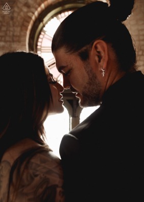 A couple deeply in love poses in front of a large, impressive clock face inside The Heights Clock Tower in Houston, Texas, during their unique and timeless engagement portrait session.