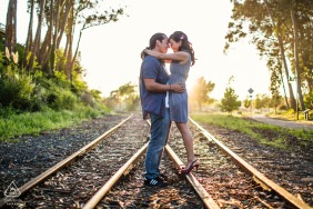The couple enjoys a scenic and relaxed engagement session in Santa Cruz, California, capturing their romantic bond along railroad tracks.