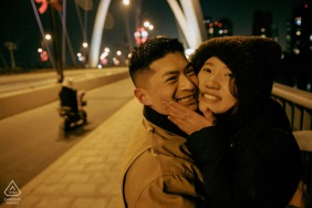 Braving the biting winter wind at the West Lake Bridge in Kaifeng, Henan, China, the couple shares a tender embrace with their faces close together during a cold seasonal session.