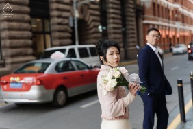 The engaged couple stands by a busy road at the Bund in Shanghai, China, looking forward with excitement as they prepare to start their next chapter together as newlyweds.
