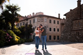 Sharing a warm and close embrace, the couple walks together through the picturesque streets of Grado, Gorizia, Italy, during their peaceful and romantic seaside engagement portrait session in Europe.