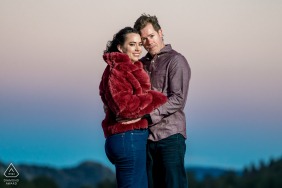 In the glow of sunset in Rocky Mountain National Park, Colorado, the couple stands side by side, their embrace framed by dramatic peaks and the last rays of daylight for a peaceful, tender portrait.
