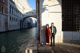Beside the famous Bridge of Sighs in Venice, Italy, the newlyweds pose for a photo with the grand architecture and canal at this iconic city, blending romance and history in the heart of Venice.